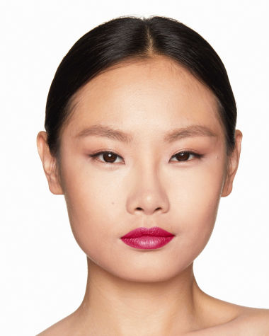 Fair-tone model with brown eyes wearing shimmery fawn eye makeup with bright, berry-pink lipstick. 