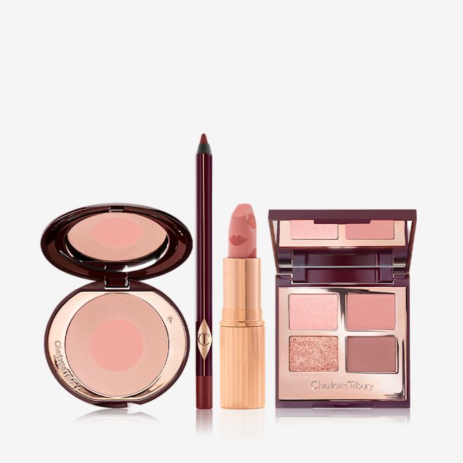 Bella's Famously Pink Look open An open, two-tone blush compact in nude pink and champagne, eyeliner in berry-brown, open lipstick in muted pink, and quad eyeshadow palette with matte and shimmery shades of pink, gold, and brown with a mirrored-lid.