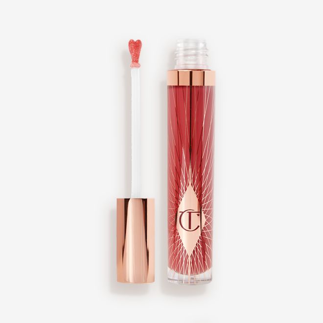 Collagen Lip Bath in Walk of No Shame open A lip gloss in a berry-pink shade with its heart-shaped applicator next to it.