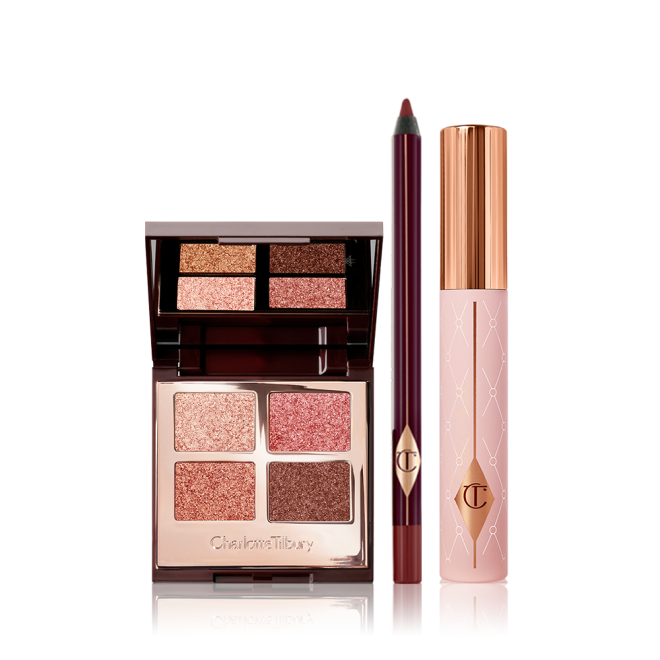 Quad, mirrored-lid eyeshadow palette with shimmery brown, gold, and pink eyeshadows with a berry-brown eyeliner pencil, and black mascara with nude pink bottle and gold-coloured lid.