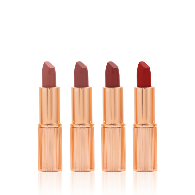 Five matte lipsticks in nude shades of red and pink in sleek, gold-coloured tubes with their lids removed.