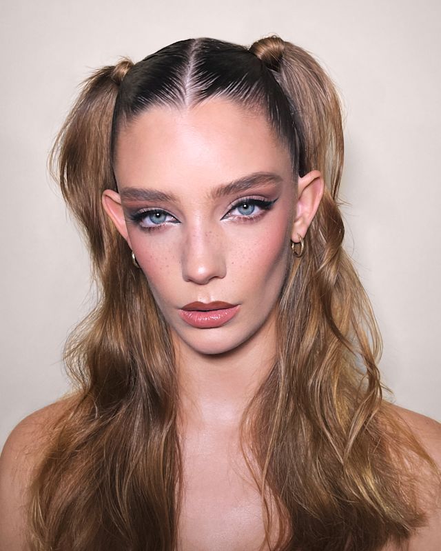 Close-up of a fair-tone model with blue eyes wearing rose-pink matte lipstick with smokey brown eye makeup, with berry rose blush.