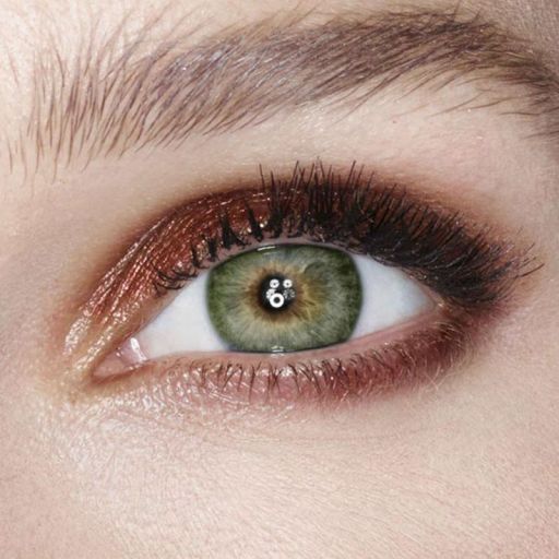 Single-eye close-up of a model wearing shimmery reddish-bronze eyeshadow. 
