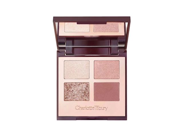 An open, mirrored-lid eyeshadow palette in nude pink, gold, and brown shades. 