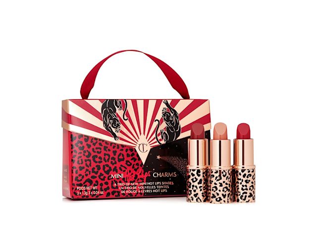 A trio of mini lipsticks in soft pink, warm berry-pink, and soft wine shades with a red-coloured gift bag with the CT logo on it. 