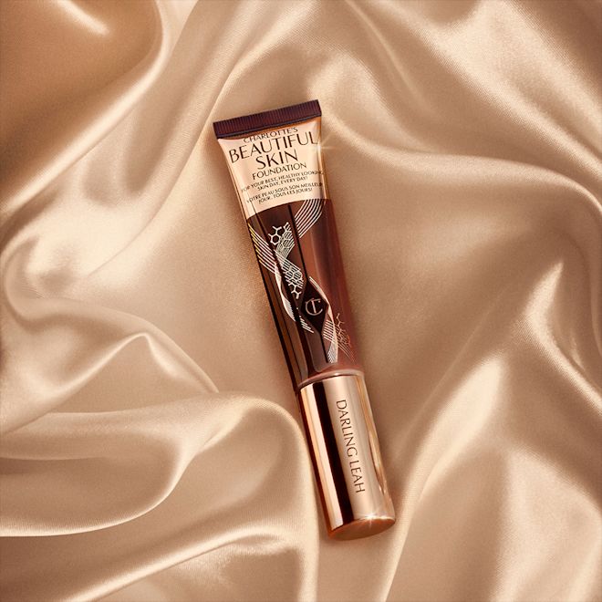 Beautiful Skin Foundation engraved banner A foundation wand in gold, engraved packaging with a dark-brown-coloured body to show the shade of the foundation inside.