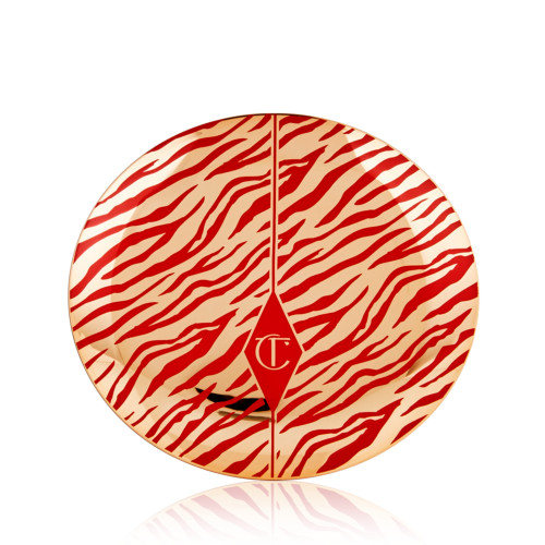 A closed powder compact with gold-coloured packaging and the CT logo printed on the lid in red and gold colour along with red tiger stripes pattern on the lid for the Lunar New Year.