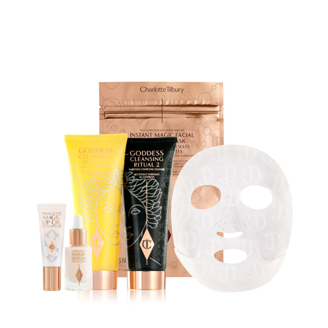 Travle-size luminous facial serum, lip oil in a white-coloured tube, oil cleanser and charcoal wash-off mask cleanser in yellow and black-coloured tubes, and a sheet mask in gold-foil packaging. 