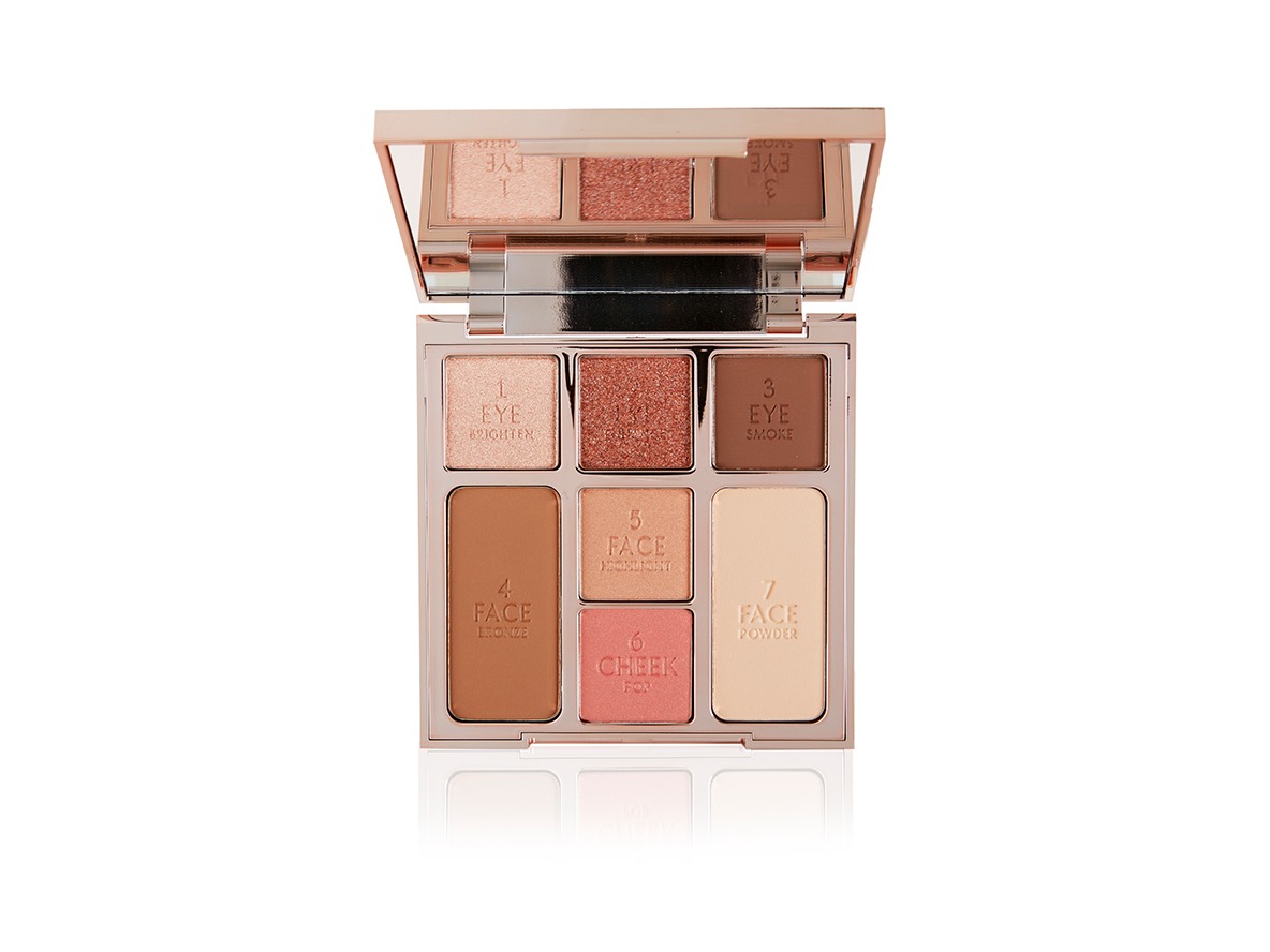 An open face palette with a mirrored-lid with three matte and shimmery eyeshadows in pink, brown, and cream shades, two blushes in peach and coral, and duo contour shades. 