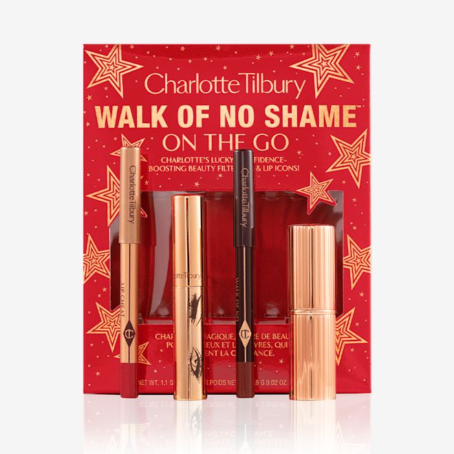 Walk of No Shame On the Go kit open with products displayed Eyeliner pencil in a berry-pink shade, mascara in a golden-coloured tube, lip liner pencil in berry-red shade, lipstick in a sleek, gold-coloured tube with red-coloured gift box with text on it reads, 'Walk of no shame on the go'.