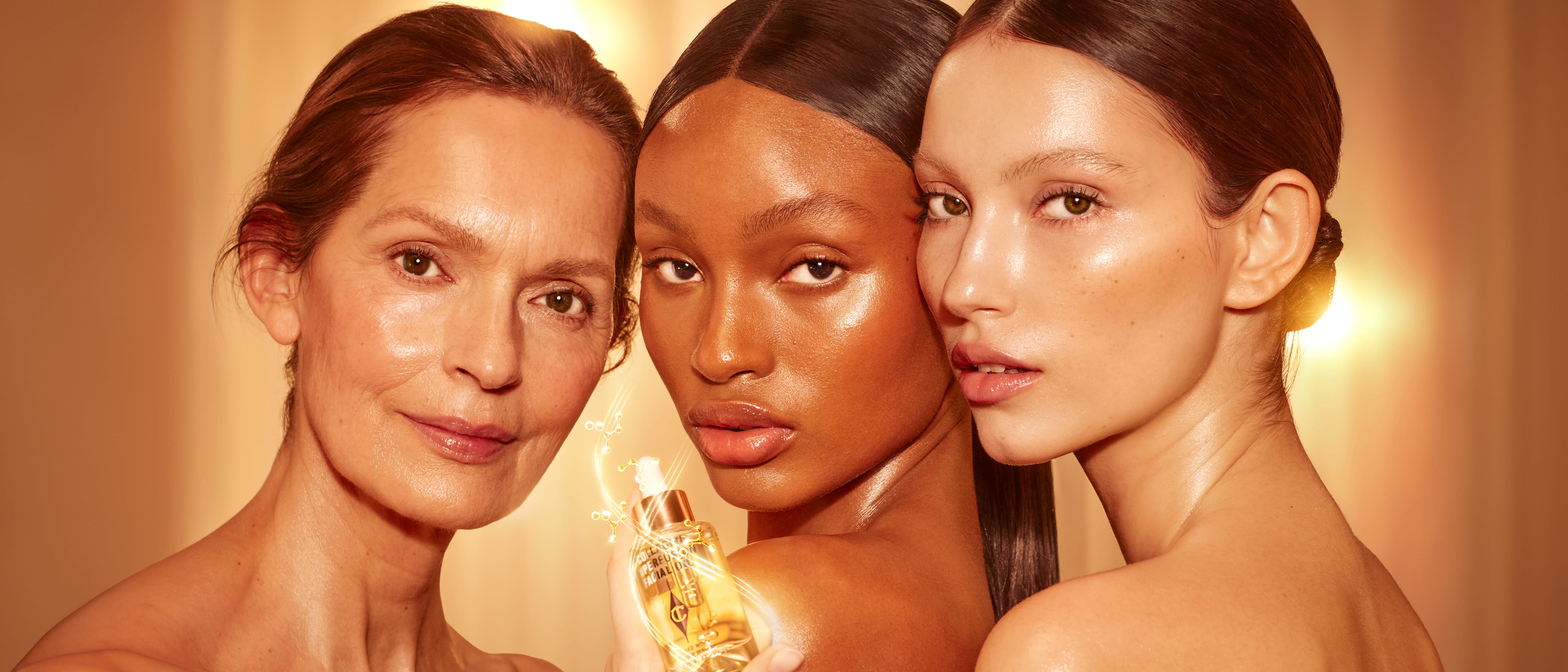 3 models of different ages and skin tones wearing no makeup and holding face oil bottle