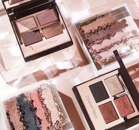 Two, open mirrored-lid quad eyeshadow palettes. One with shimmery and matte eyeshadows in pink champagne, metallic blush pink, mink brown and antiqued brown colours, and the other with matte and shimmery eyeshadows in rose gold, chocolate brown, champagne, and black.