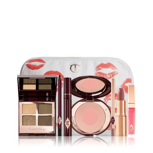 A white makeup bag with a quad eyeshadow palette in shades of green and gold, a brown eyeliner pencil, mascara, an open two-tone blush in nude pink, a warm pink lip liner pencil, a warm rose lipstick, and a bright pink lip gloss. 