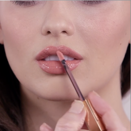 La modella applica il Lip Lustre in Sweet Stiletto per dare alle labbra una lucentezza rosa tenue.