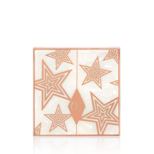 A closed eyeshadow palette with a pearly-white lid with gold stars printed all over. 