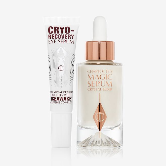 Cryo-Recovery Eye Serum and Magic serum closed Eye serum in a white-coloured tube with geometric patterns on the front in a reflective, silver colour along with luminous, facial serum in a glass bottle with a white and gold dropper lid.