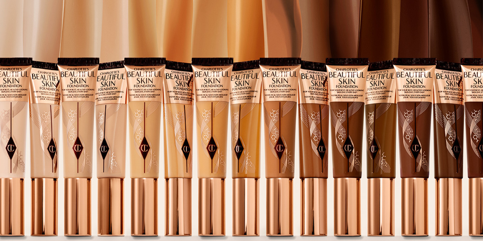 A collection of foundation wands in packaging that display the colour of the foundation inside for fair, light, medium, medium-light, medium-dark, and dark skin tones with sleek, gold-coloured lid.