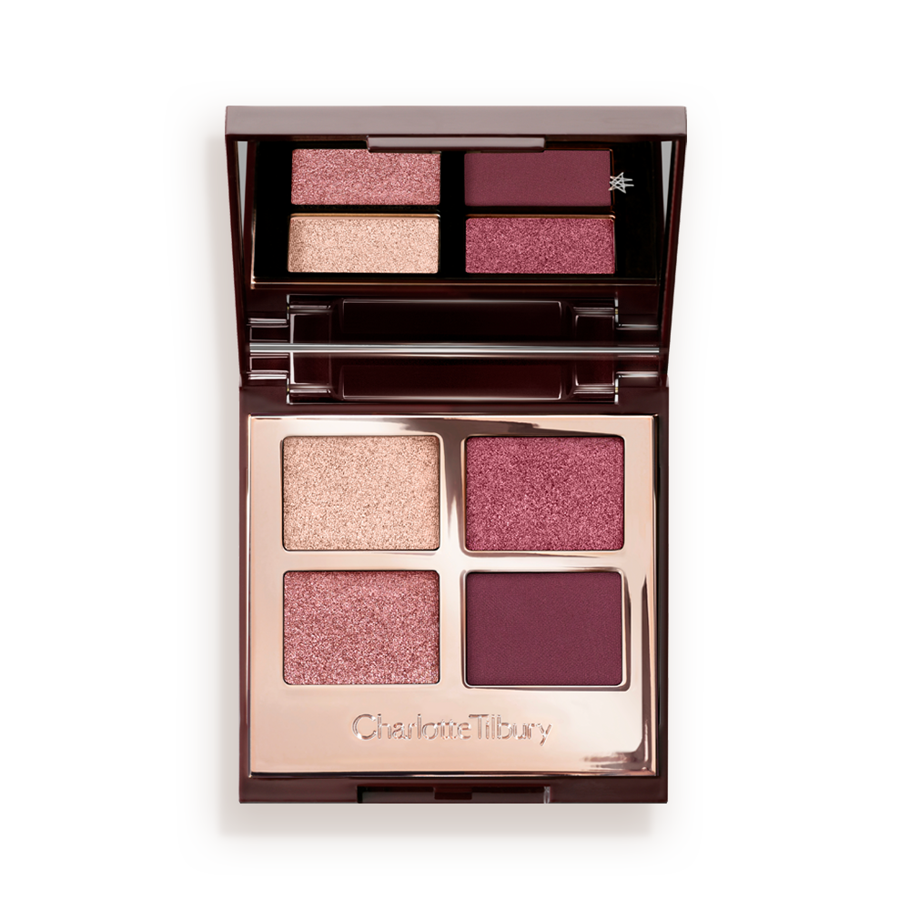 A mirrored-lid, quad eyeshadow palette with eyeshadows in shades of pink, plum, and champagne. 