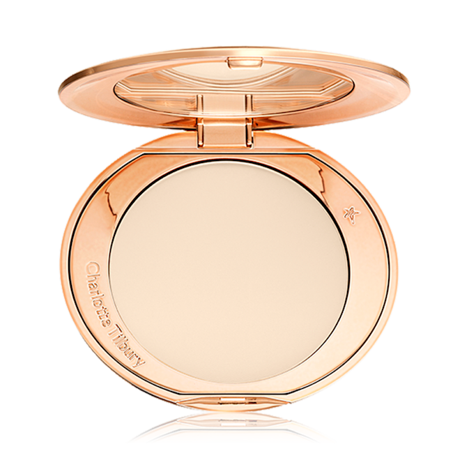 An open, pressed powder compact in a cream colour. 