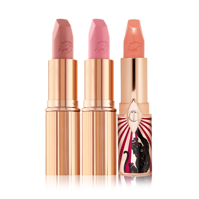 Three open lipsticks, two matte lipsticks in nude shades of brown and pink and a satin-finish lipstick in a light coral shade.