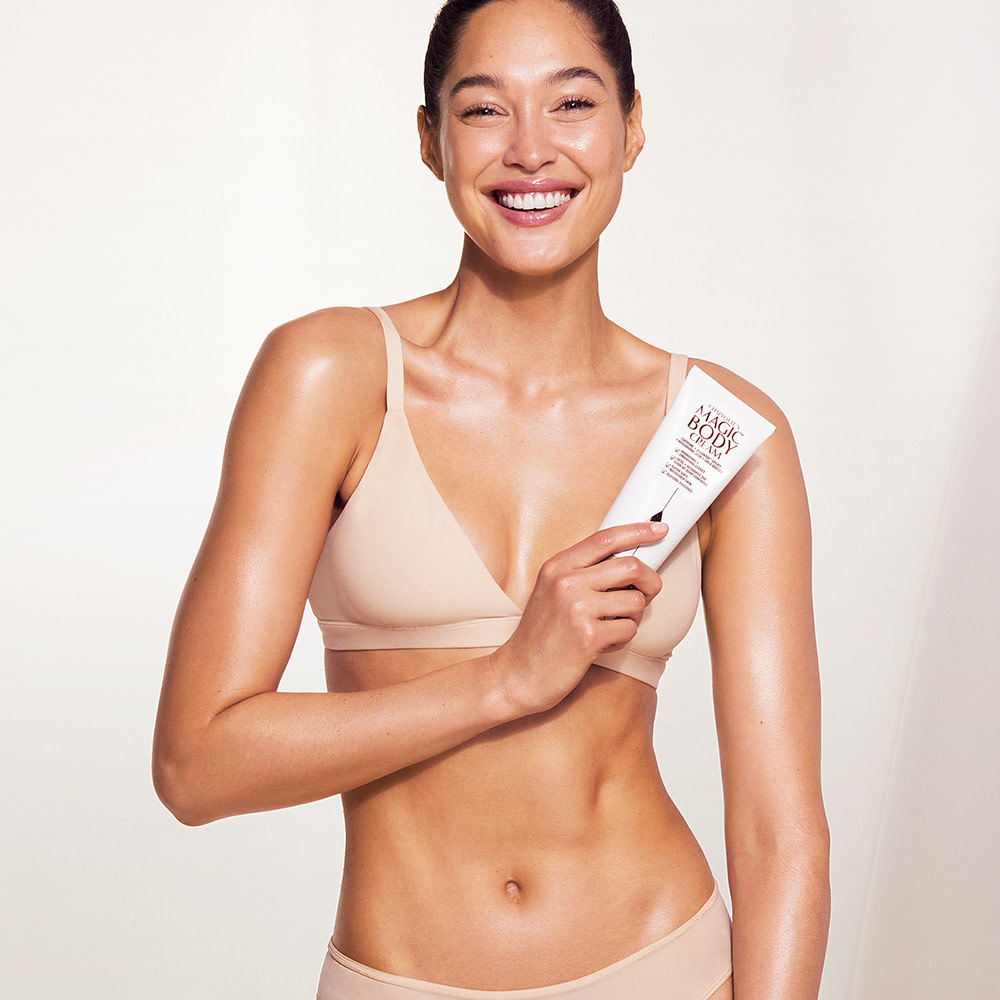 Eden holding Charlotte's Magic Body Cream, a hydrating, instant-turnaround body moisturiser