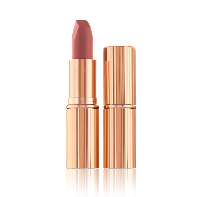 Two lipsticks, with and without lid, in a mid-toned muted nude-rose matte shade, in sleek, gold-coloured tubes. 