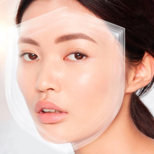 Fair-tone brunette model wearing a smoothing primer with a satin-finish with an illusion of a shield over her face to depict protection from UV rays.