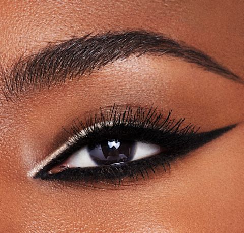 Modella che indossa l'eyeliner bianco-nudo come un'accattivante linea grafica