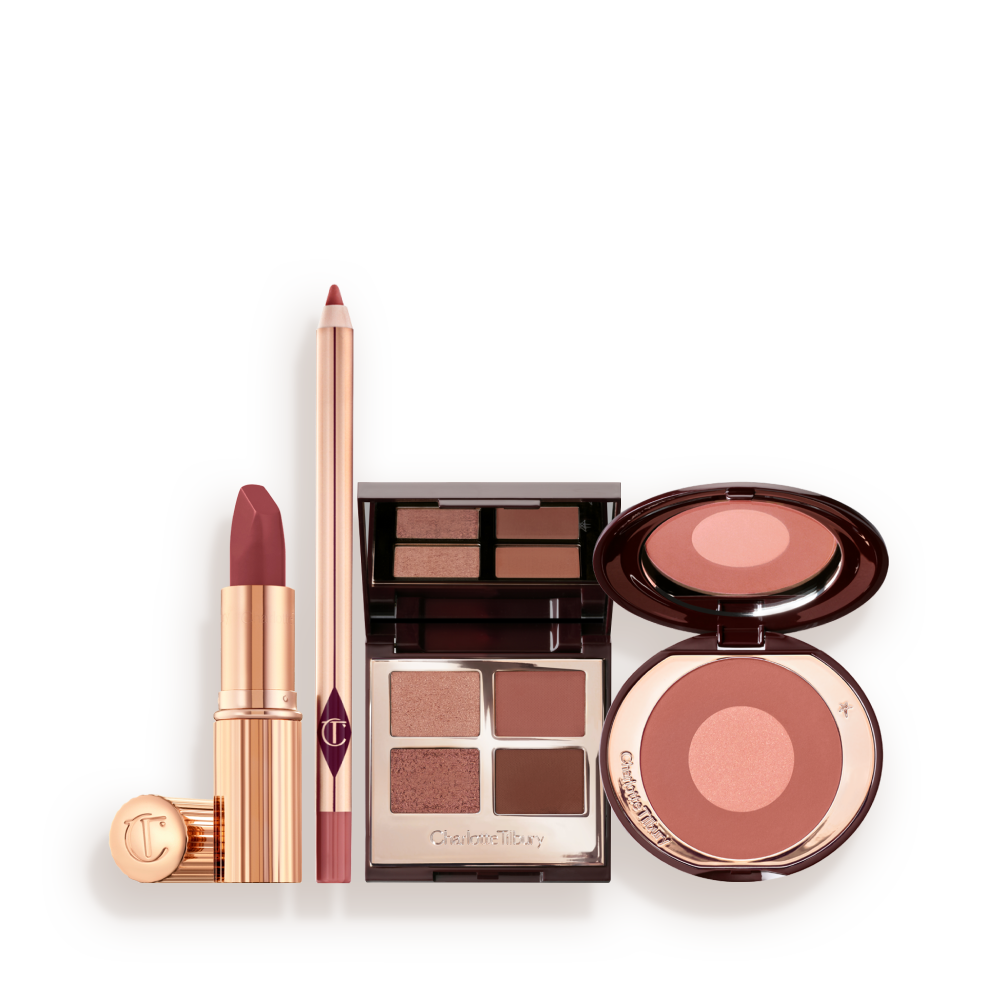 A makeup kit containing a two-tone pink and rose gold blush, a berry and pink quad eyeshadow palette, a nude-pink lip liner pencil, and rose-pink lipstick. 