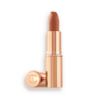 An open lipstick in a fresh, neutral nude peach matte shade, in a sleek, gold-coloured tube.