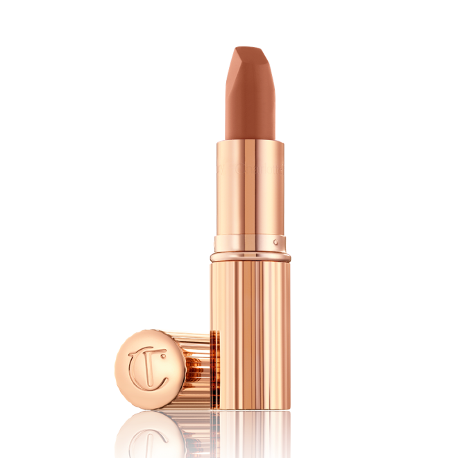 An open lipstick in a fresh, neutral nude peach matte shade, in a sleek, gold-coloured tube.