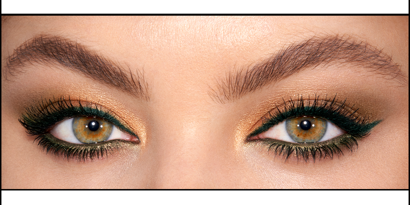 Eye close-up of a light-tone model with hazel eyes wearing shimmery gold eyeshadow with bottle-green khaki-coloured eyeliner.