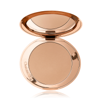 An open mirrored-lid bronzer compact in a light shade. 