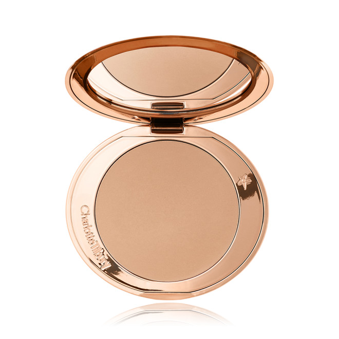 An open mirrored-lid bronzer compact in a light shade. 