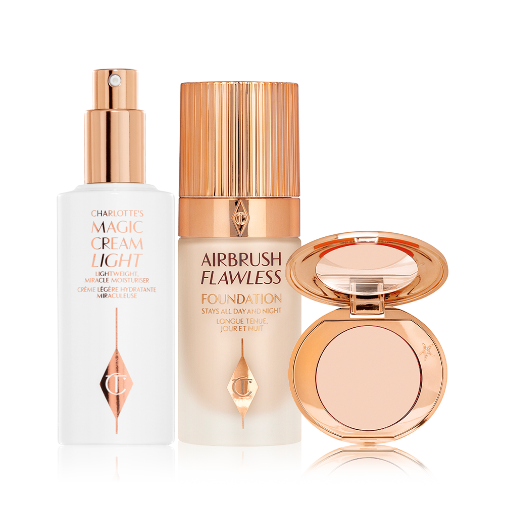 Face cream in a white-coloured bottle with a gold-coloured pump dispenser, foundation in a frosted glass bottle with a gold-coloured lid, and pressed powder compact with a mirrored-lid.