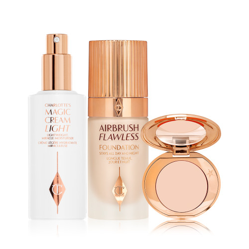 Face cream in a white-coloured bottle with a gold-coloured pump dispenser, foundation in a frosted glass bottle with a gold-coloured lid, and pressed powder compact with a mirrored-lid.