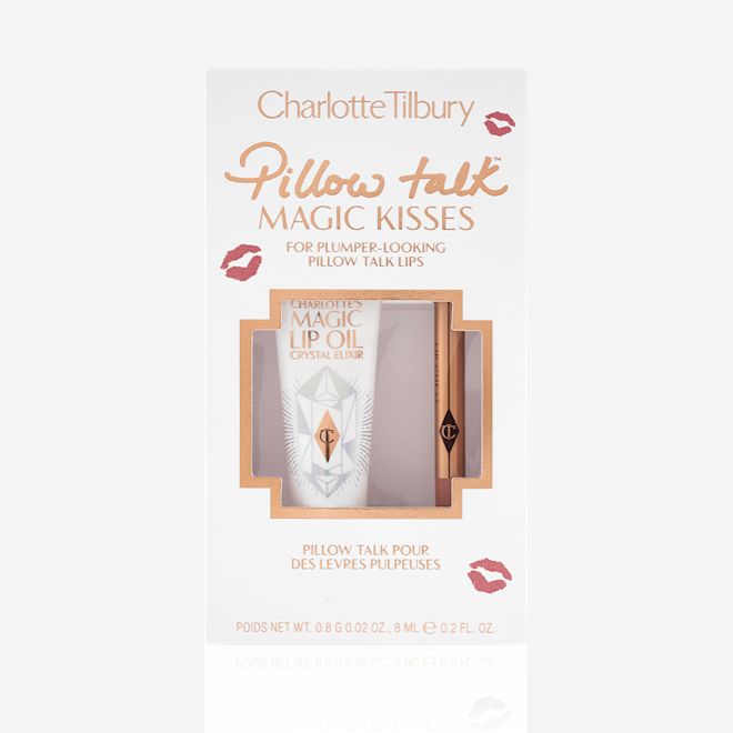 Pillow Talk Magic Kisses kit packed Lip oil in a white-coloured tube with a gold-coloured lid along with a lip liner pencil in a nude pink shade in a white packaging box text on it that reads, 'Pillow Talk Magic Kisses'