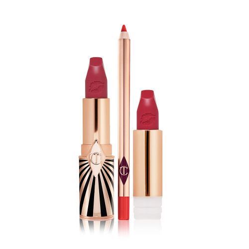 Lipstick in a dark, berry-pink shade with its refill next to it, both with lids removed, and a lip liner pencil in a bold, orange-red colour.
