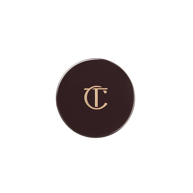 A dark brown eyeshadow pot lid with Charlotte Tilbury written on the lid in gold. 