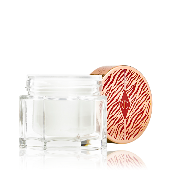 Magic Cream Lunar Year lid removed Thick, pearly-white cream in an open glass jar with its gold-coloured lid with red a red tiger-print on it next to it.