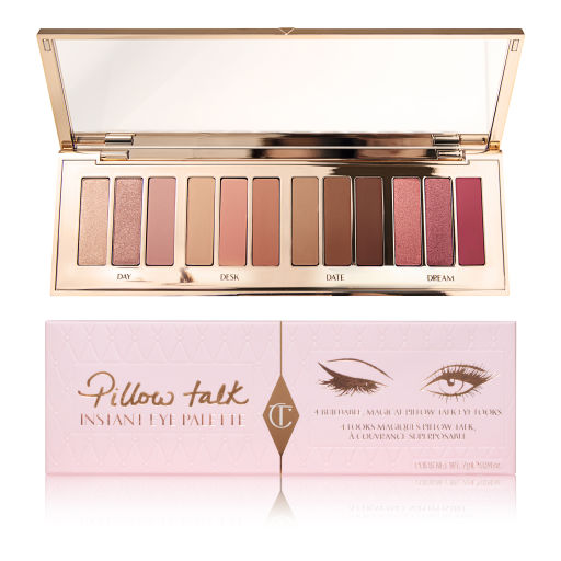An open, mirrored-lid, eyeshadow palette with nude shades with nude-pink box packaging. 