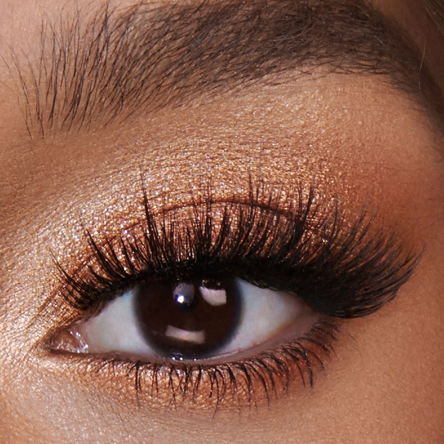 Brown eye close-up with shimmery peach and champagne eye makeup. 