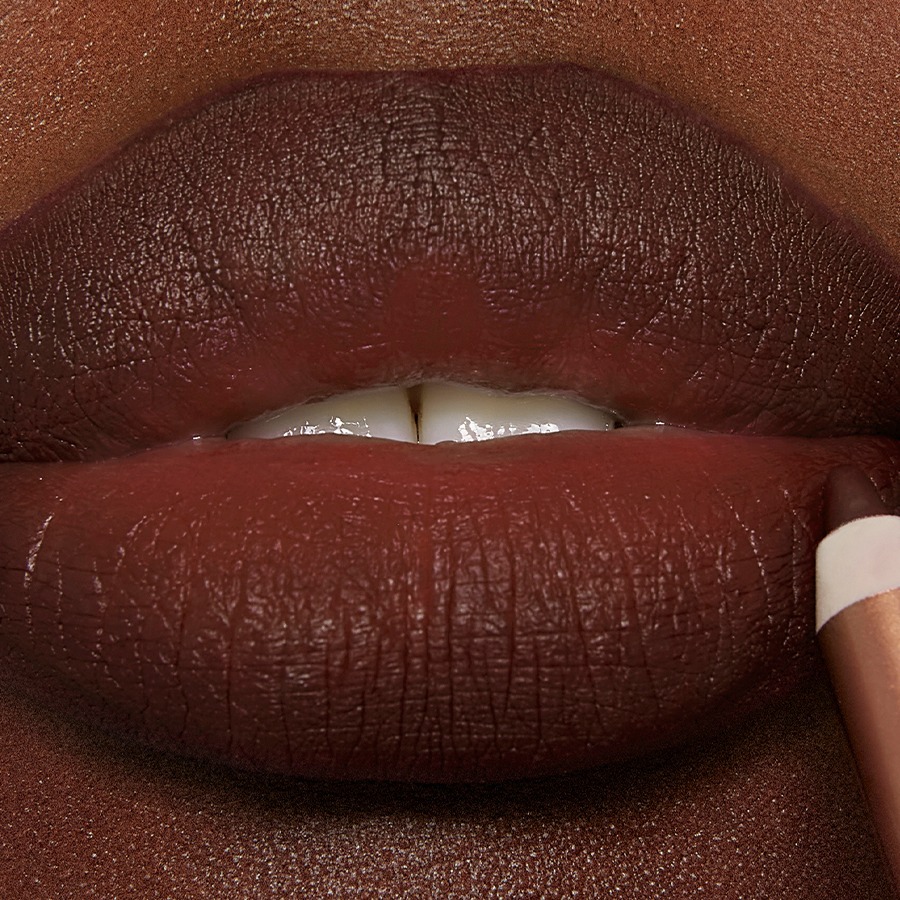 Model wearing Pillow Talk Intense Lip Cheat deep brown-pink lip liner