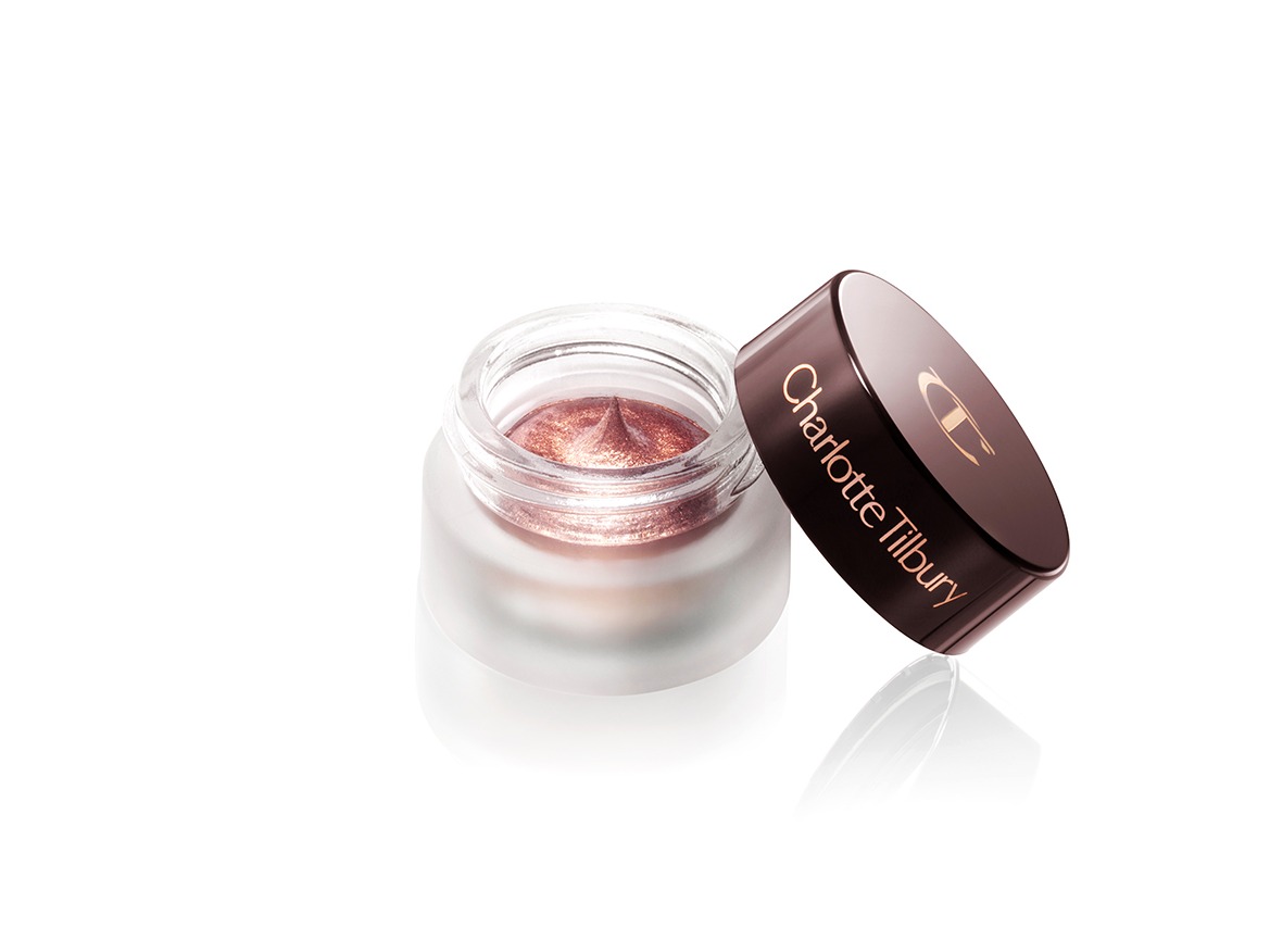 A dark rose gold cream eyeshadow in an open glass pot with a dark brown-coloured lid. 