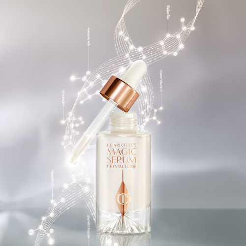 Crystal Magic Serum in a clear, glass bottle with a glass dropper in rose-gold packaging. 