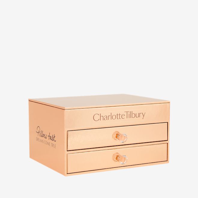 Pillow Talk Dreams Makeup Vault Box closed A makeup and skincare vault in the shape of a chest of drawers in gold-colour with sparkly handles on the drawers.
