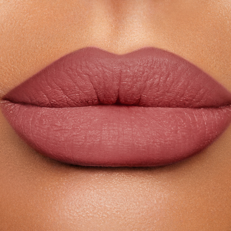 La modelo lleva el lápiz de labios Lip Cheat de Charlotte en un tono rosa-marrón medio