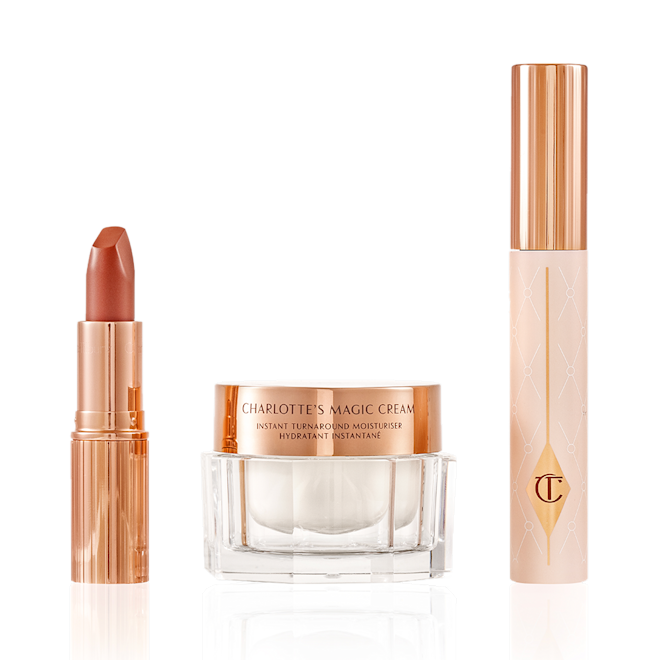 Charlotte Tilbury's Magic Icons kit displayed Pearly-white face cream in a glass jar with a gold-coloured lid, black mascara in a pink tube with a gold-coloured lid, and golden-peach matte lipstick in a gold-coloured tube.