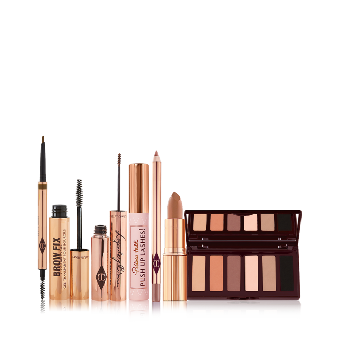 An open, double-ended eyebrow pen and brush, open eyebrow gel, and open eyebrow tint, all in gold-coloured tubes with a closed mascara in a nude pink tube with a gold-coloured lid, nude brown lip liner pencil, nude peach lipstick, and a 6-pan eyeshadow palette with a mirrored lid with matte eyeshadows in brown peach, and black shades. 