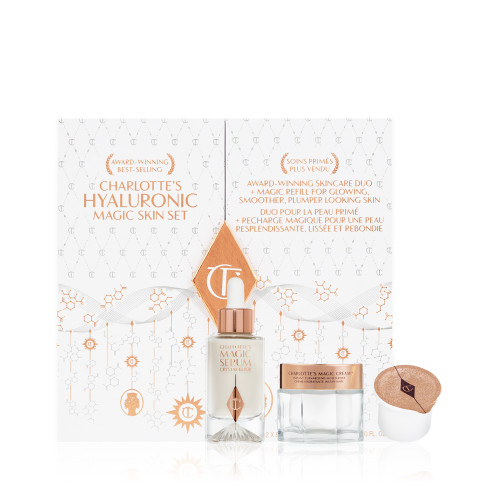 White and gold-coloured skincare box that includes a luminous face serum in a glass bottle and pearly white face cream in a glass jar with a gold-coloured lid that comes with a sample. 